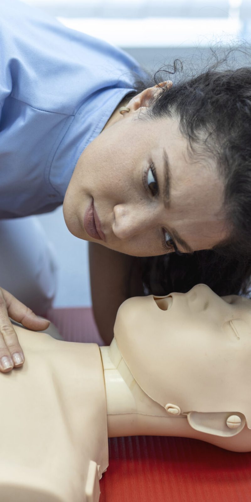 CPR class with instructors talking and demonstrating firt aid, compressions ans reanimation procedure. Cpr dummy