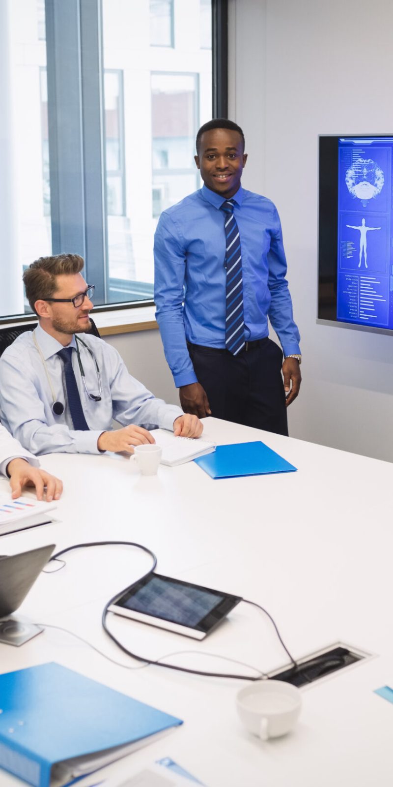 Doctor giving presentation to team of interim doctors at conference room